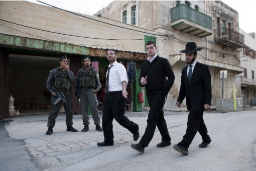 Israli soldiers at a checkpoint near Ibrahimi Mosque guarding ultra orthodox settlers on their saturday walkaround through the palestine part of the old city of Hebron.